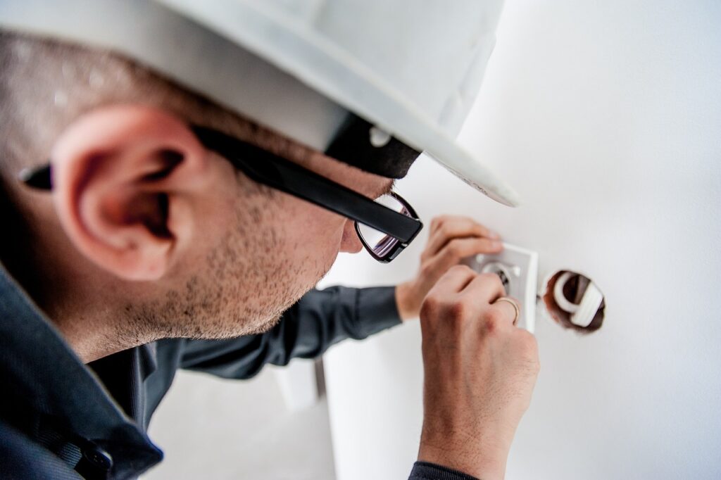 Electrician working on wiring in a London property, provided by Advanced Corporation.